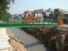 trabalhadores instalando o piso concreto da passarela
