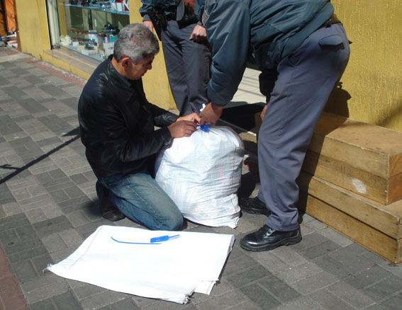 Agente da Subprefeitura e Polícia Militar fazem o ensacamento de parte do material