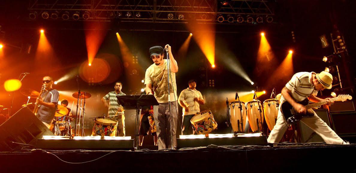 Banda Nação Zumbi em apresentação ao vivo em um palco iluminado