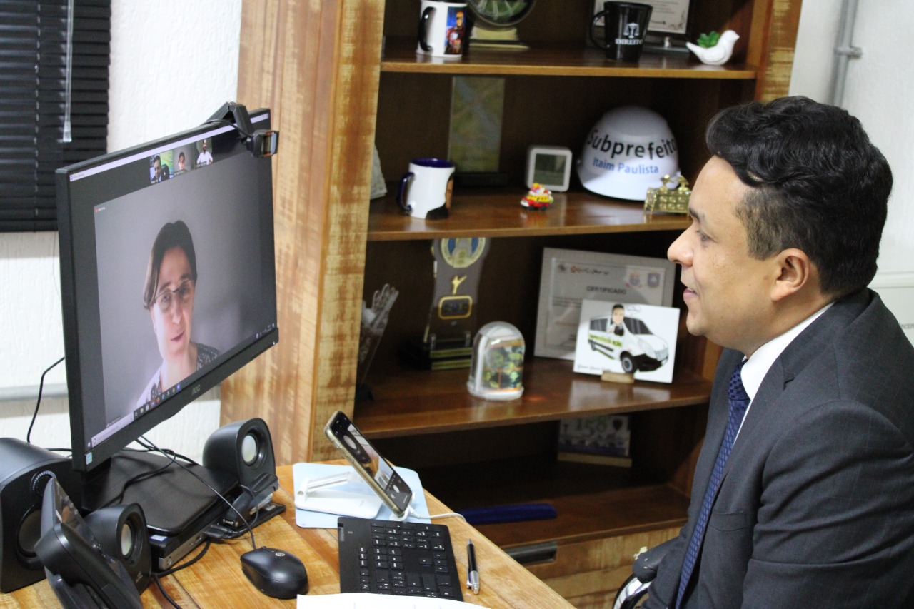 Na imagem aparece o subprefeito do Itaim Paulista, Gilmar Souza Santos, olhando para a tela do seu computador participando de uma videoconferência com LAB Itaim.