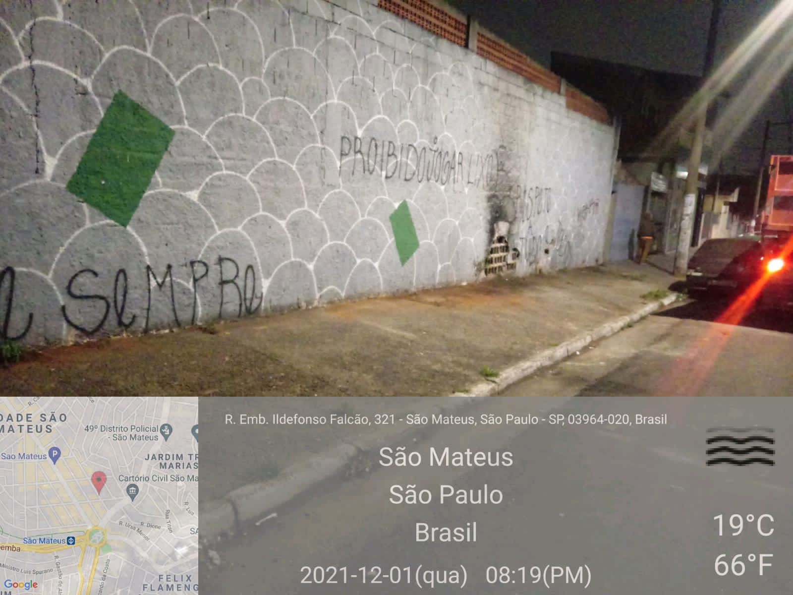 Em uma rua iluminada, um caminhão basculante está parado em frente a um muro pintado e com a calçada limpa. Foto identificada como rua Embaixador Ildefonso Falcão, 321, São Mateus