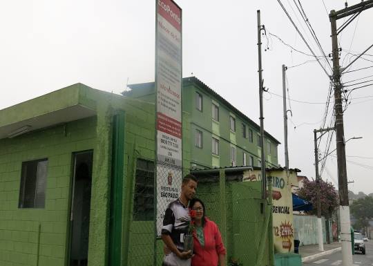 Leandro e Rute seguram a muda e se juntam para uma selfie em frente ao Ecoponto