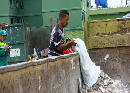 munícipe lançando entulho na caçamba disponibilizada para restos de construção