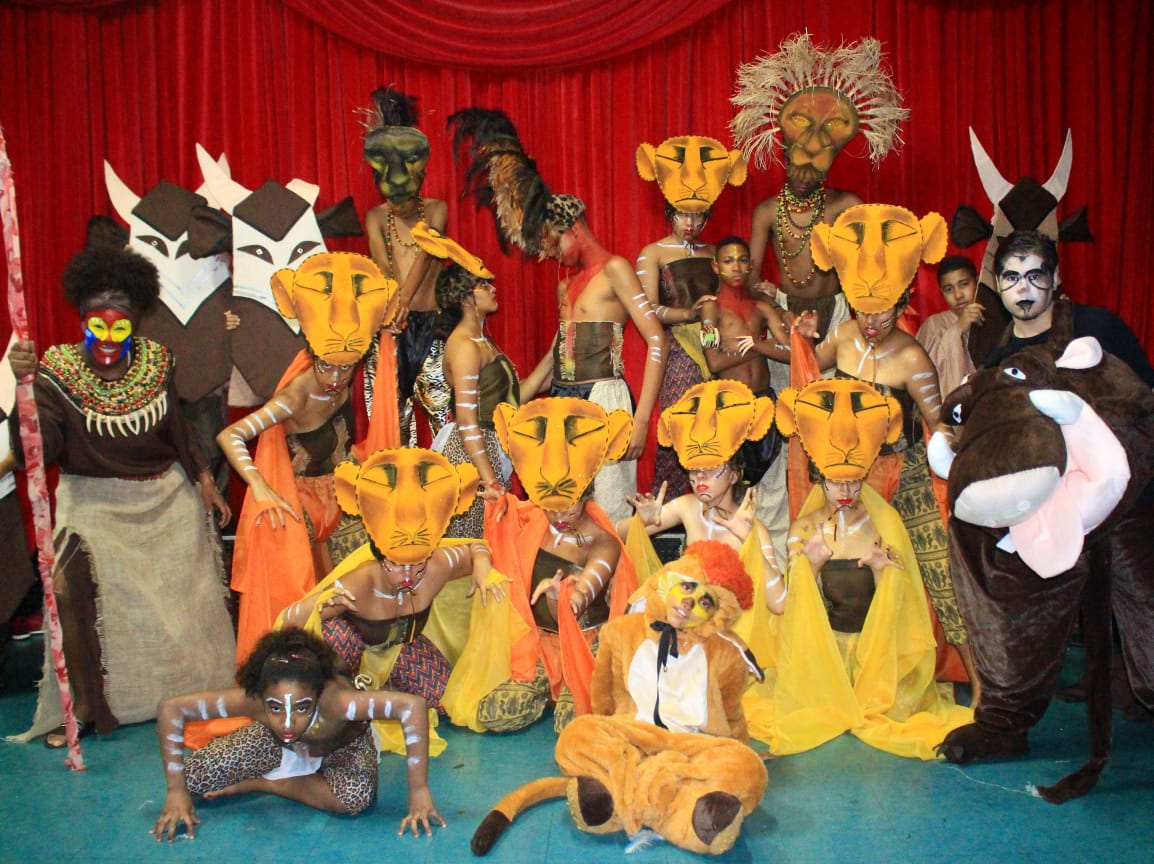 Grupo com máscaras representando leões para a apresentação de teatro do Rei Leão.