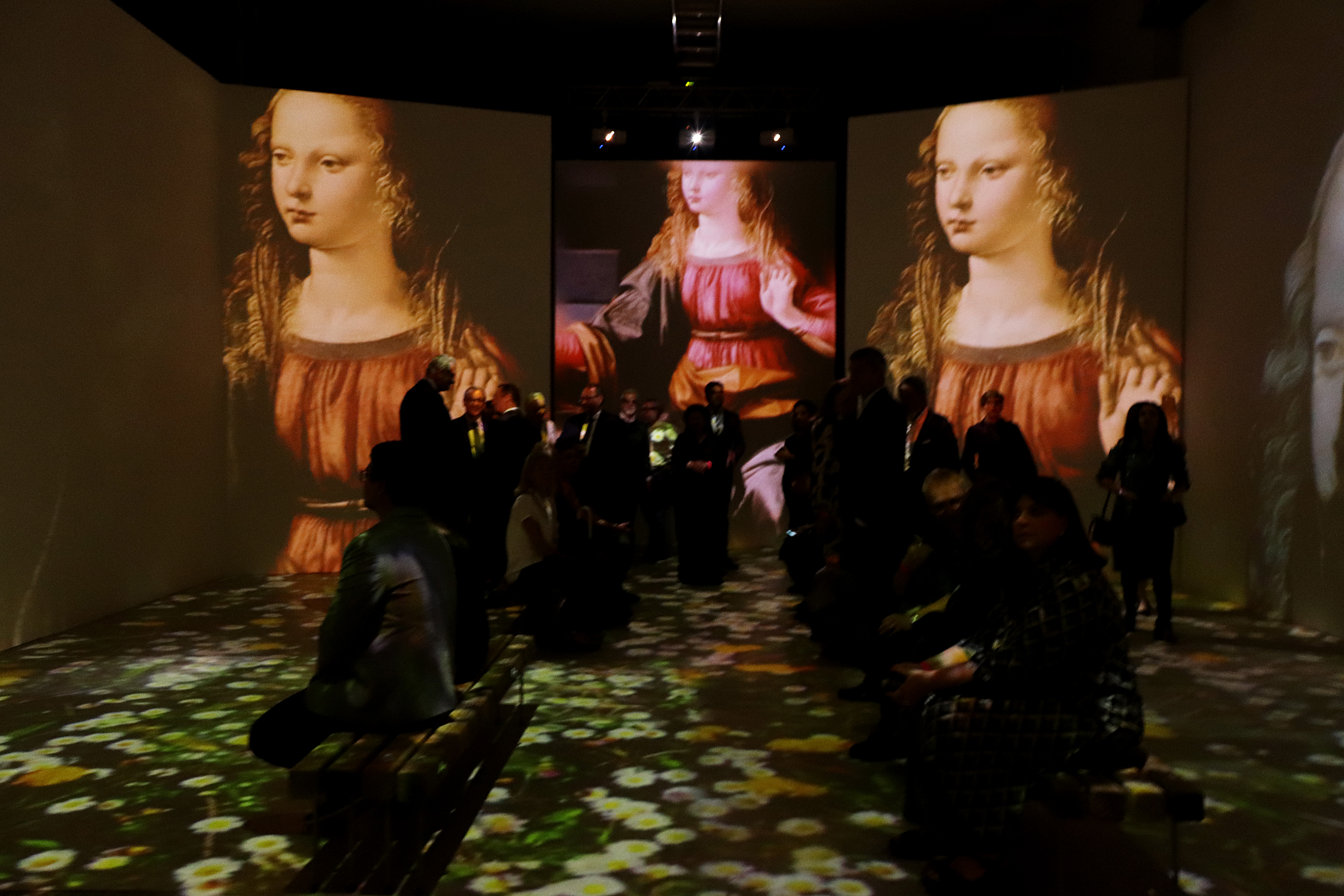 Imagens da exposição com foco no quadro do Da Vinci de uma mulher de cabelos claros e ondulados e olhando para baixo