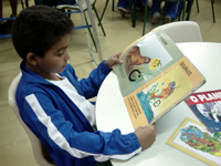 Criança lê em biblioteca da rede municipal de ensino