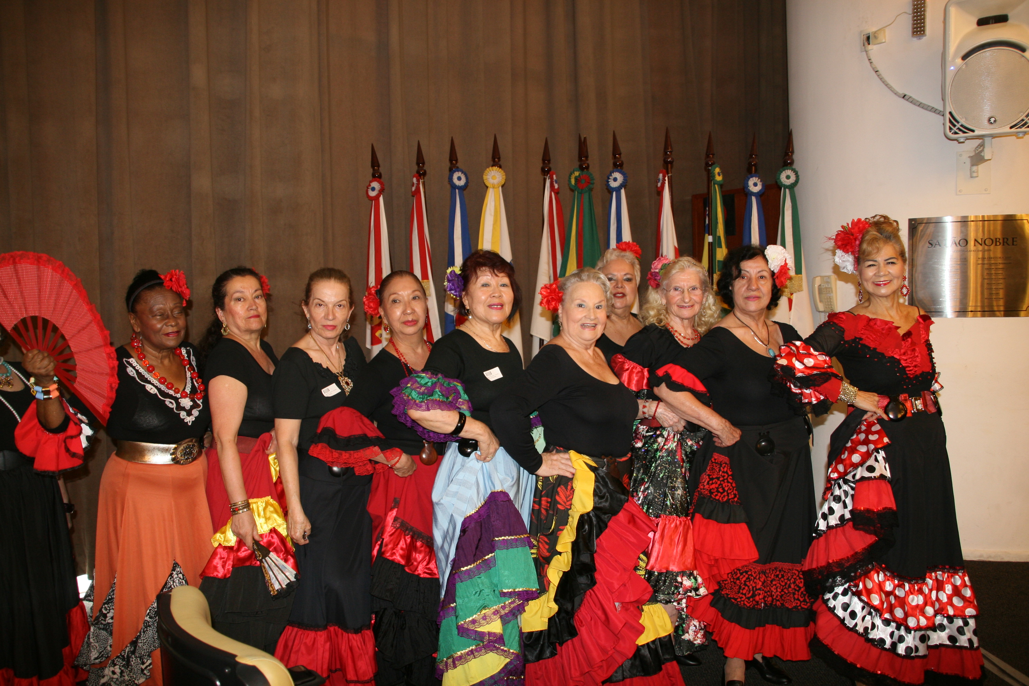 Mulheres vestidas de espanholas reunidas para dançar juntas em pose