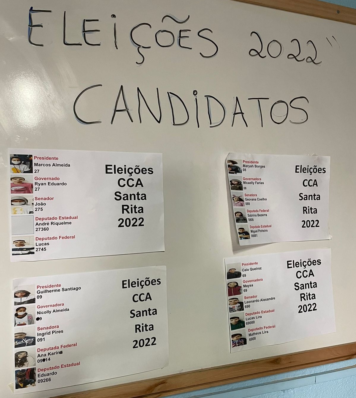 quadro branco com a frase “eleições 2022, candidatos”, e as fotos e número de cada um. 