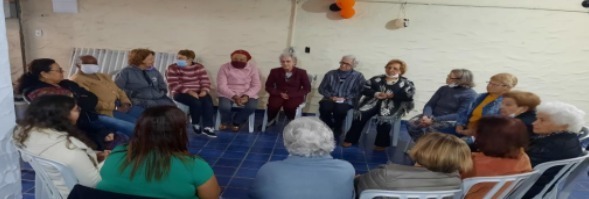 Grupo de idosos reunido em roda de conversa.