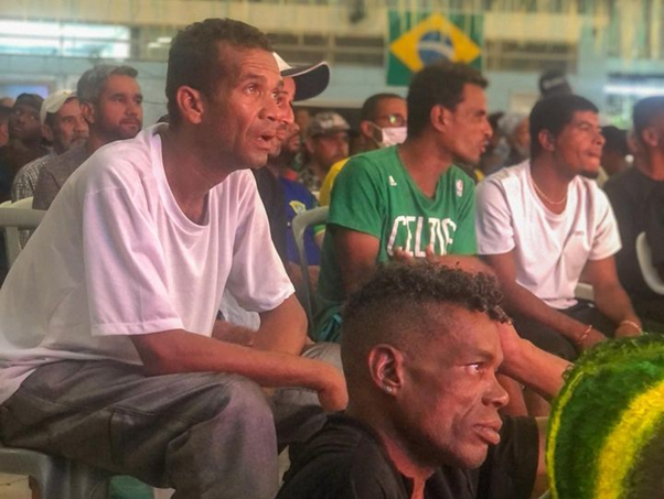 Homens sentados assistindo ao jogo do Brasil