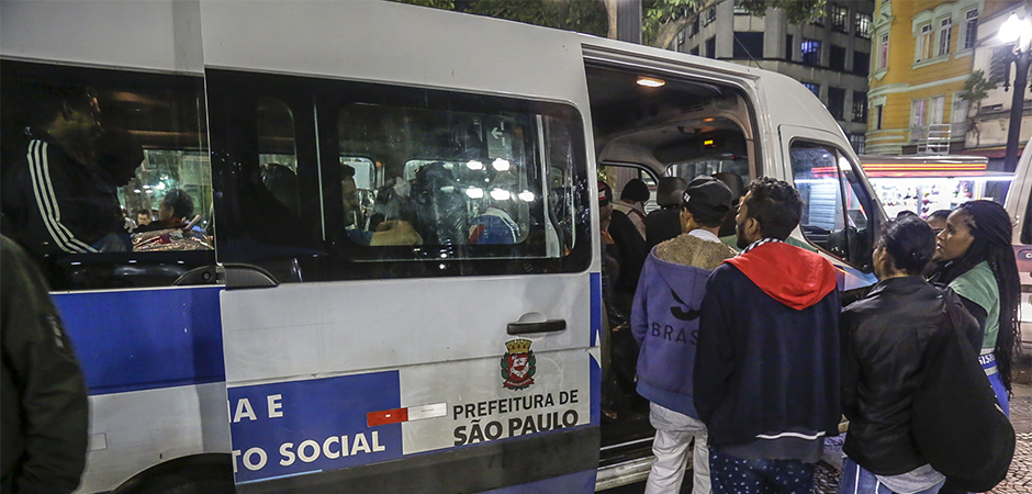 Durante a noite nas ruas de são paulo, uma van da Assistência Social está parada aguardando a entrada de pessoas em situação de rua que aceitaram acolhimento dos orientadores socioeducativos