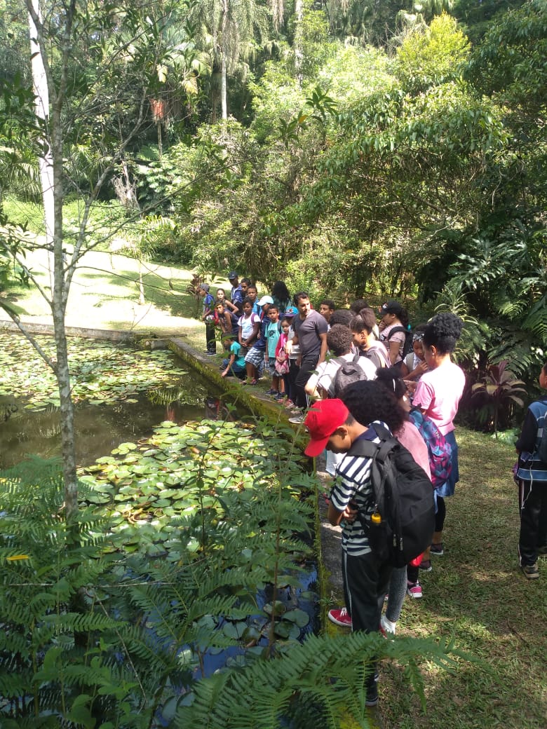 Dezenas de crianças estão dentro de uma trilha num parque. 