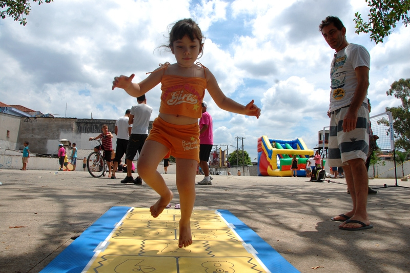 Uma criança está pulando amarelinha na rua