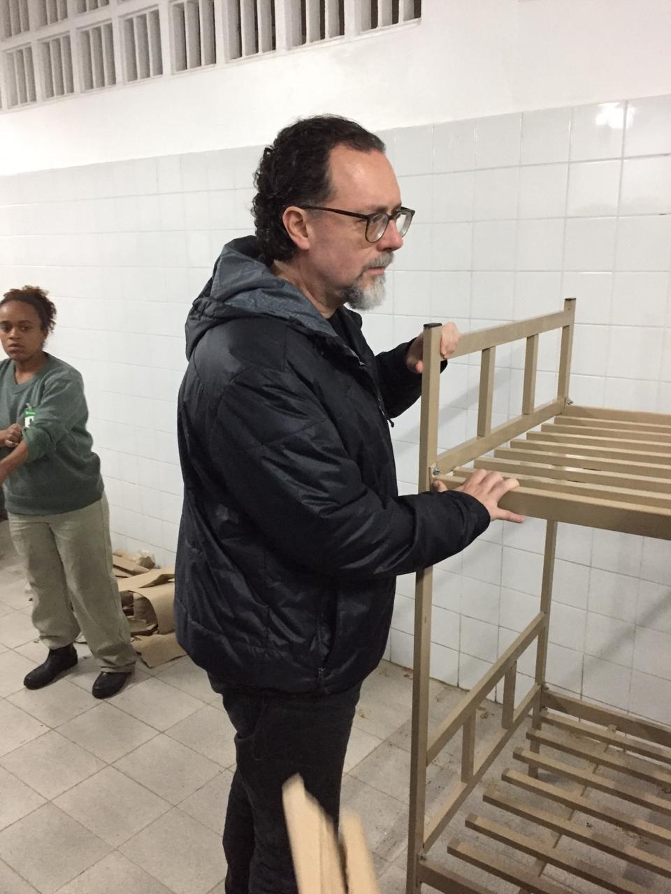 Secretário municipal Carlos Bezerra Jr. fiscaliza clube durante visita, ao lado de uma das camas disponibilizadas no programa.
