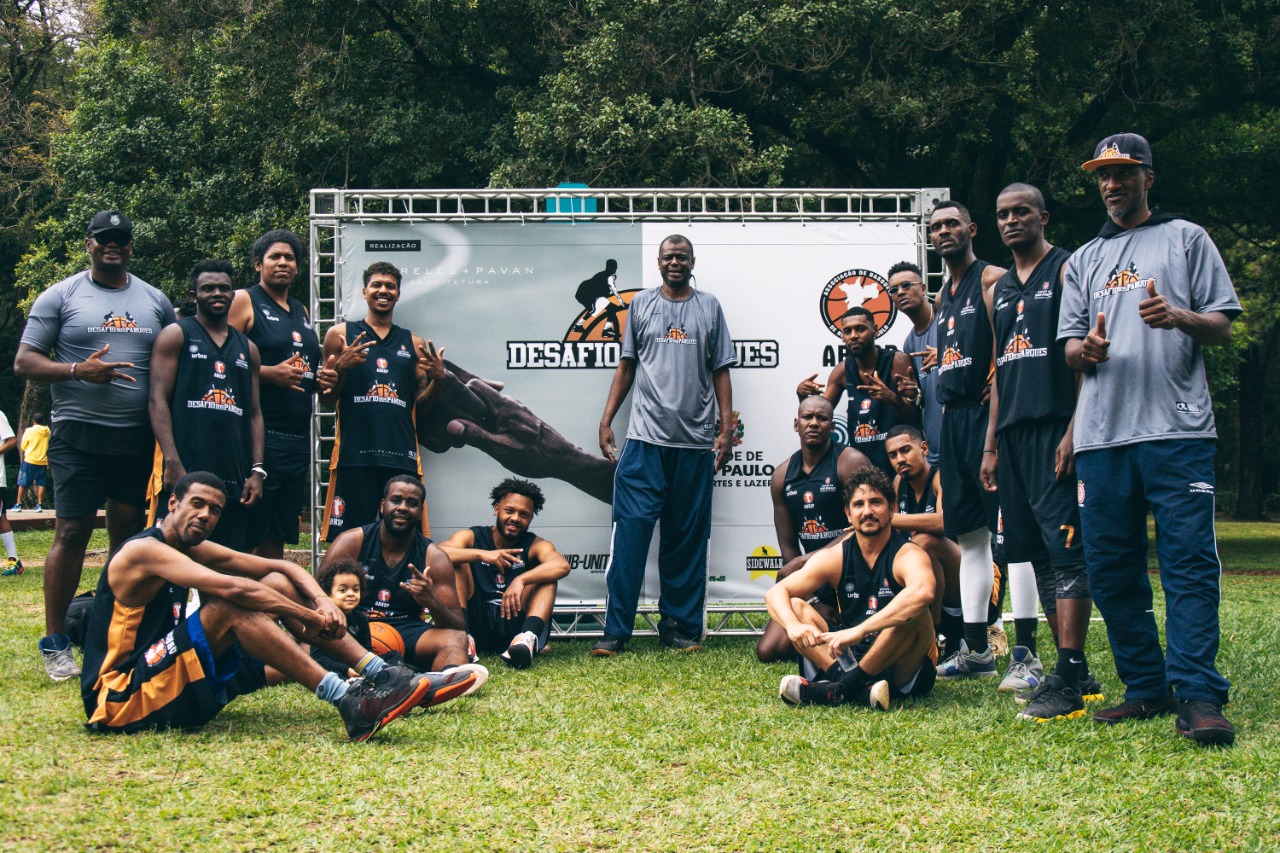 Na imagem, atletas de basquete posam para foto em grupo.
