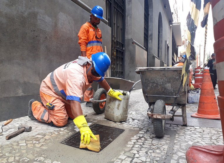 Foto de vários trabalhadores da Subprefeitura da Sé fazendo a manutenção de calçadas na região central.