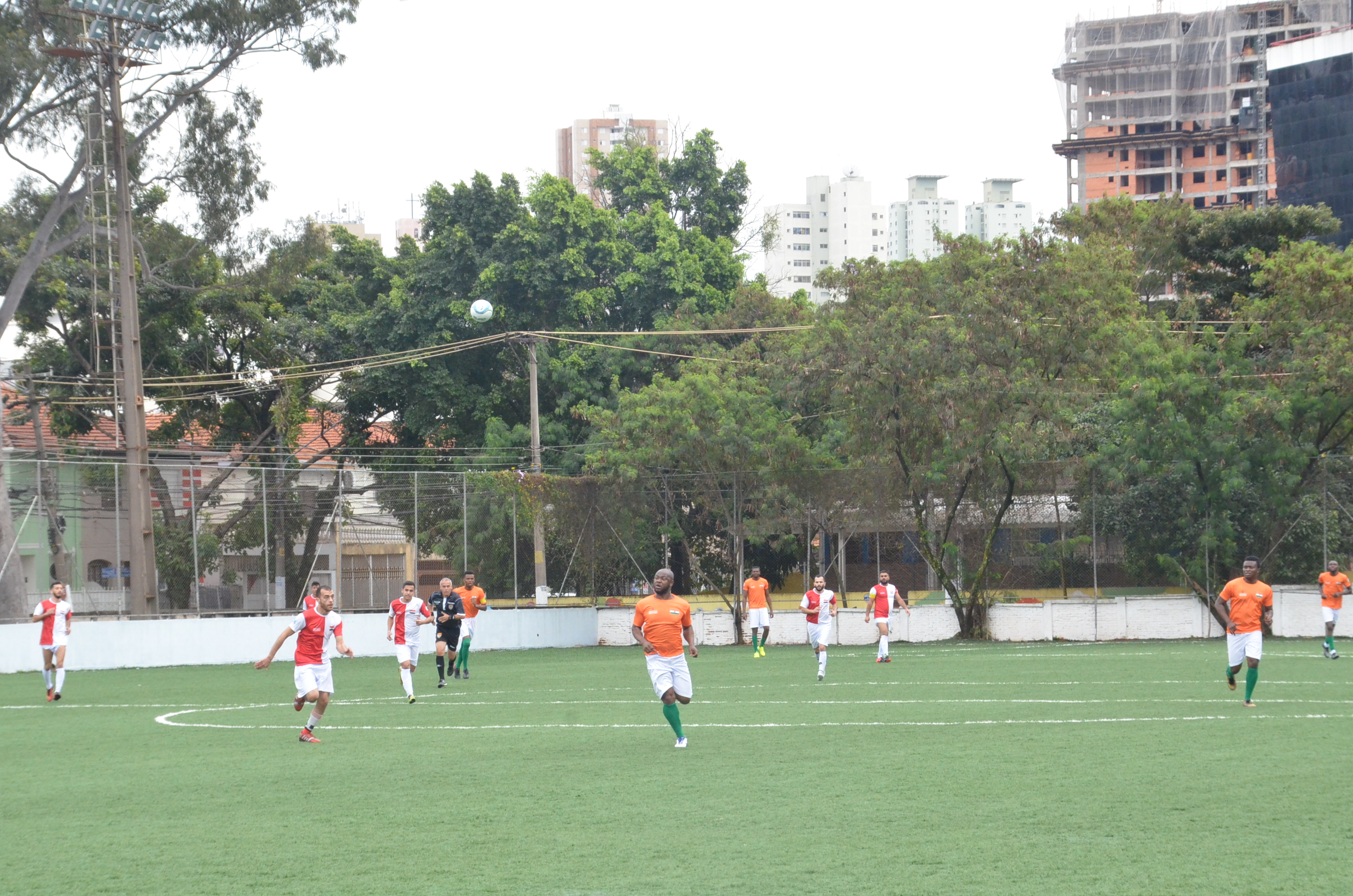 Jogadores de futebol jogando no campo, na Copa dos Refugiados
