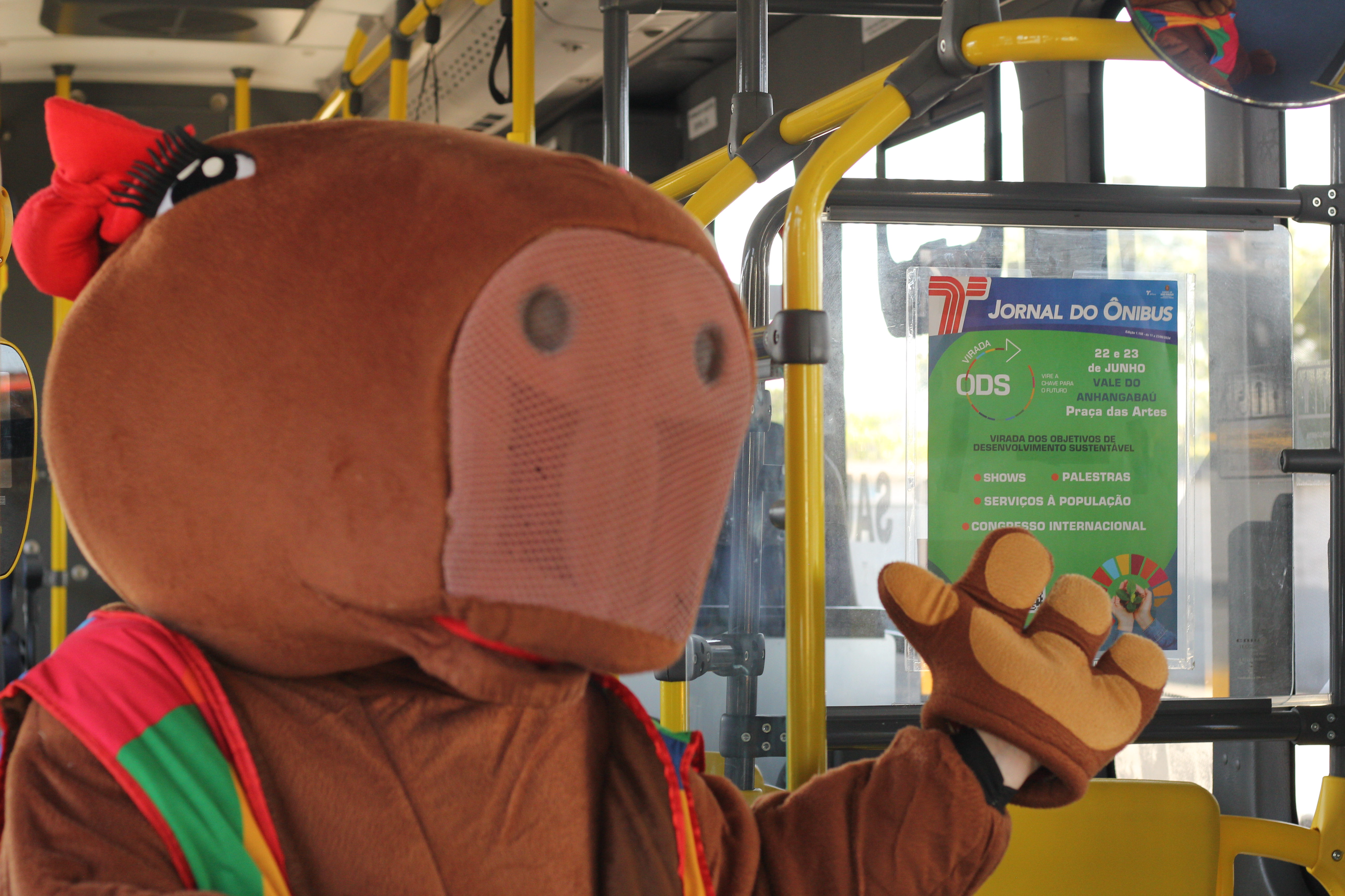 Mascote ao lado do Jornal do Ônibus