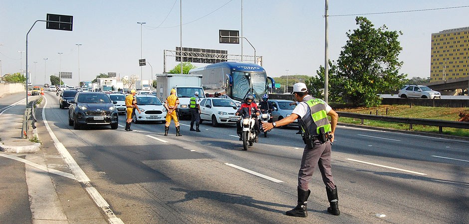 Foto de motociclistas que estiverem na Marginal Tietê e foram parados numa blitz e convidados a assistir uma palestra de 15 minutos ministrada por um policial militar e um agente de trânsito.