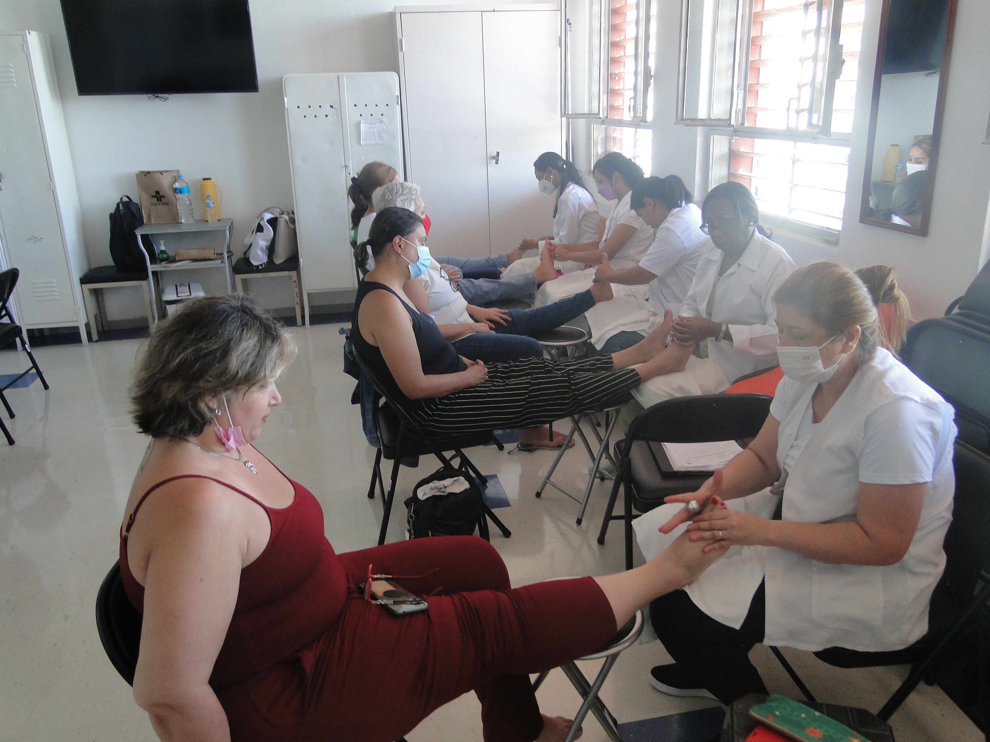 Imagem das Mulheres recebendo massagem podal na sala de meditação do HSPM