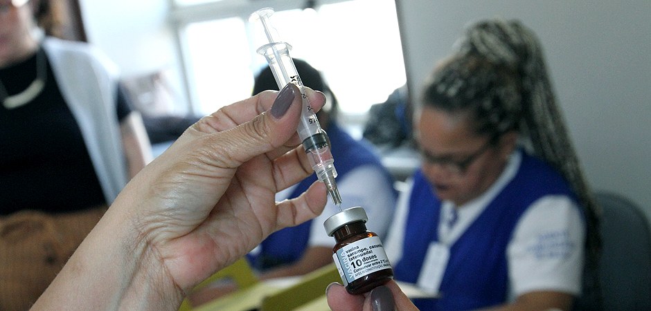 Foto da mãe de uma enfermeira aplicando vacina em um cidadão da cidade de São Paulo.