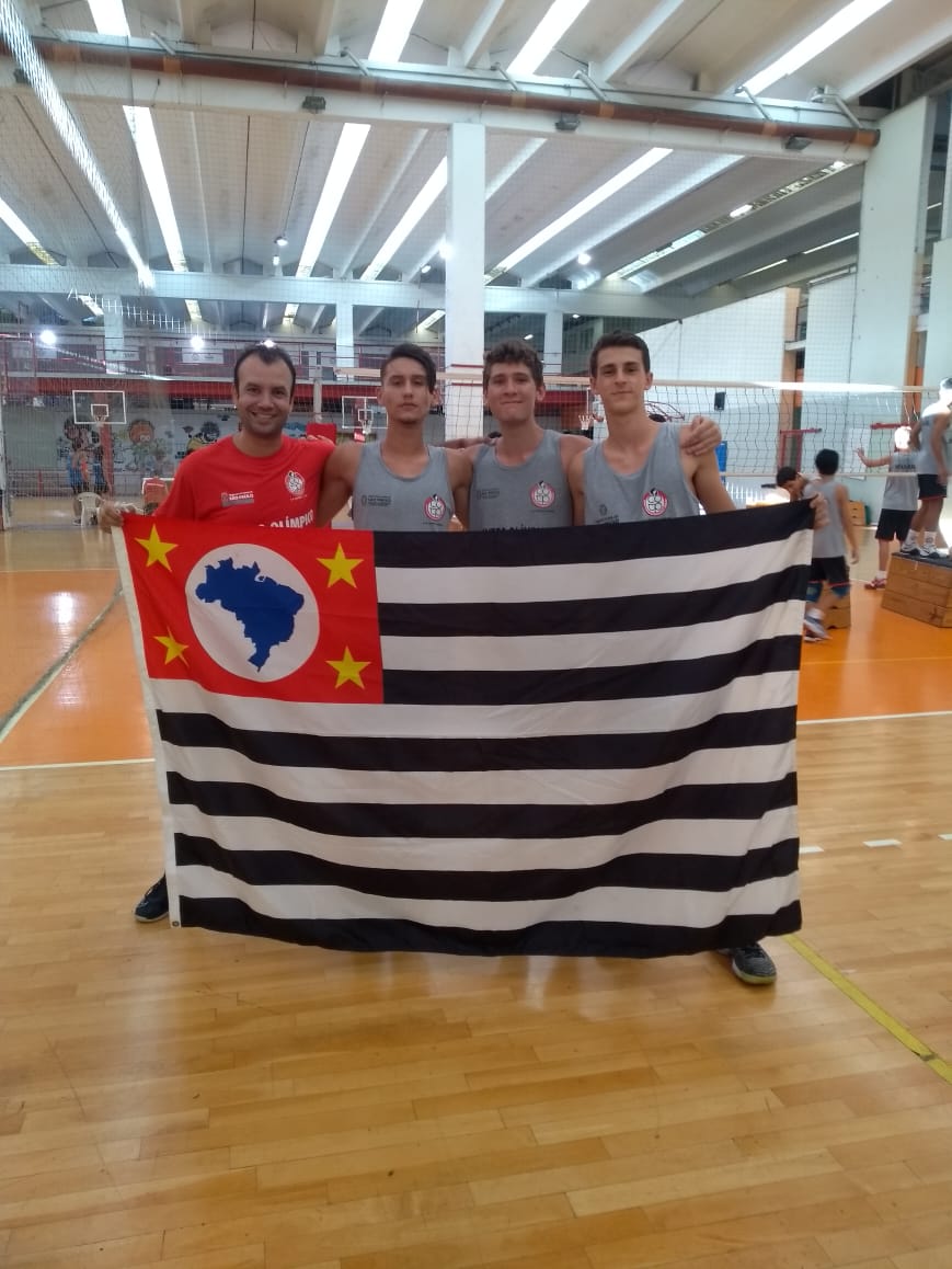Na imagem, o técnico e os três meninos posam com a bandeira do estado de São Paulo