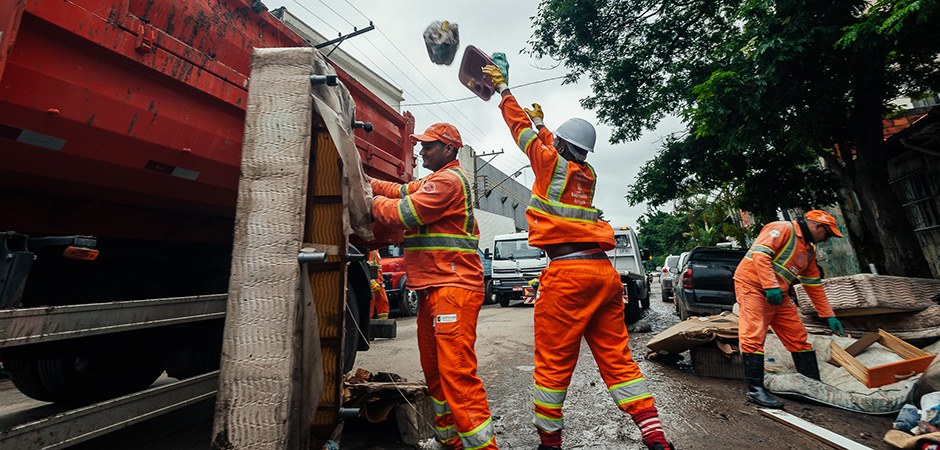 Foto de vários funcionários da Prefeitura de São Paulo fazendo os serviços de zeladoria pela cidade depois das fortes chuvas.