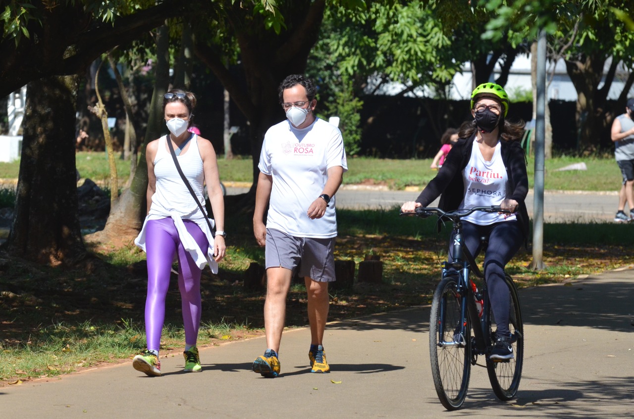 Na imagem, pessoas caminhando e andando de bicicleta de máscara, no parque das Bicicletas.