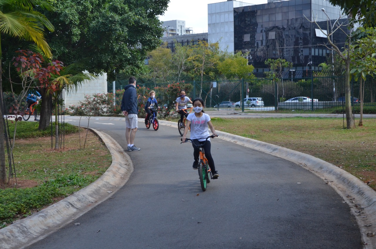 Na imagem, crianças usando máscara e andando de bicicleta no Parque das Bicicletas.