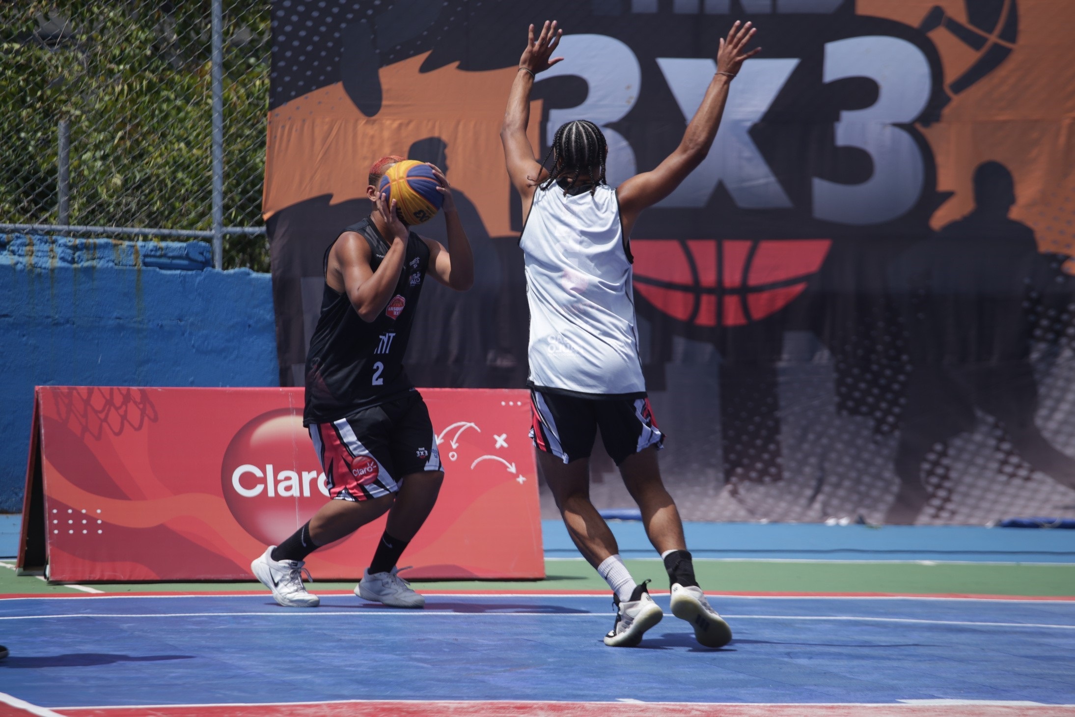 Na imagem dois atletas jogando basquete 