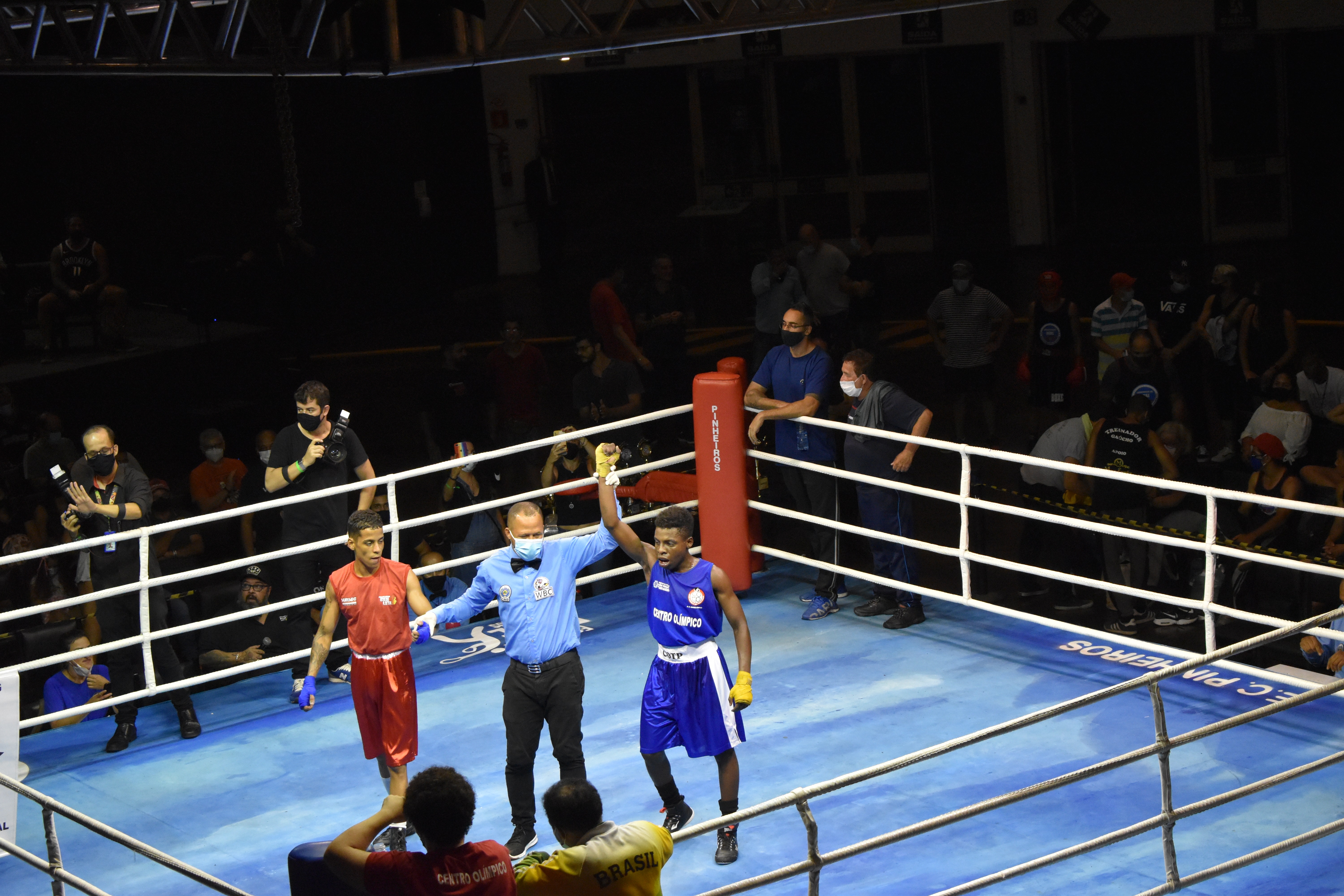 Na imagem, o arbitro levantando o braço do vencedor da luta, o atleta do Centro Olímpico Christofer Quadros 
