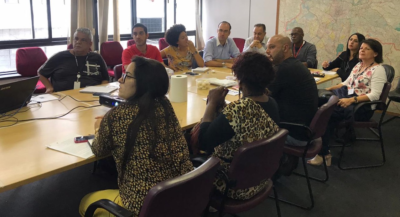 Foto da mesa com os vários participantes do encontro com sete subprefeituras da capital para apresentar o programa Mãos e Mentes Paulistanas.