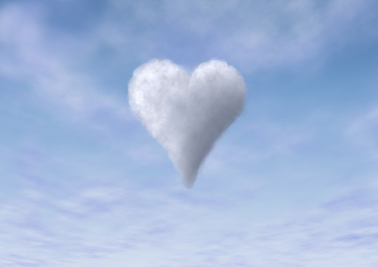 No centro de um céu azul limpo, está uma nuvem em formato de coração branco.