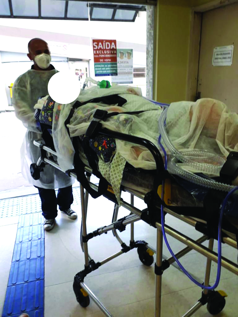 Foto do paciente sendo levado por enfermeiro no dia da alta hospitalar 