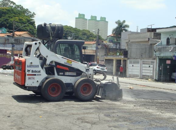 Foto de um trator fazendo a manutenção de uma das calçadas da cidade de São Paulo.