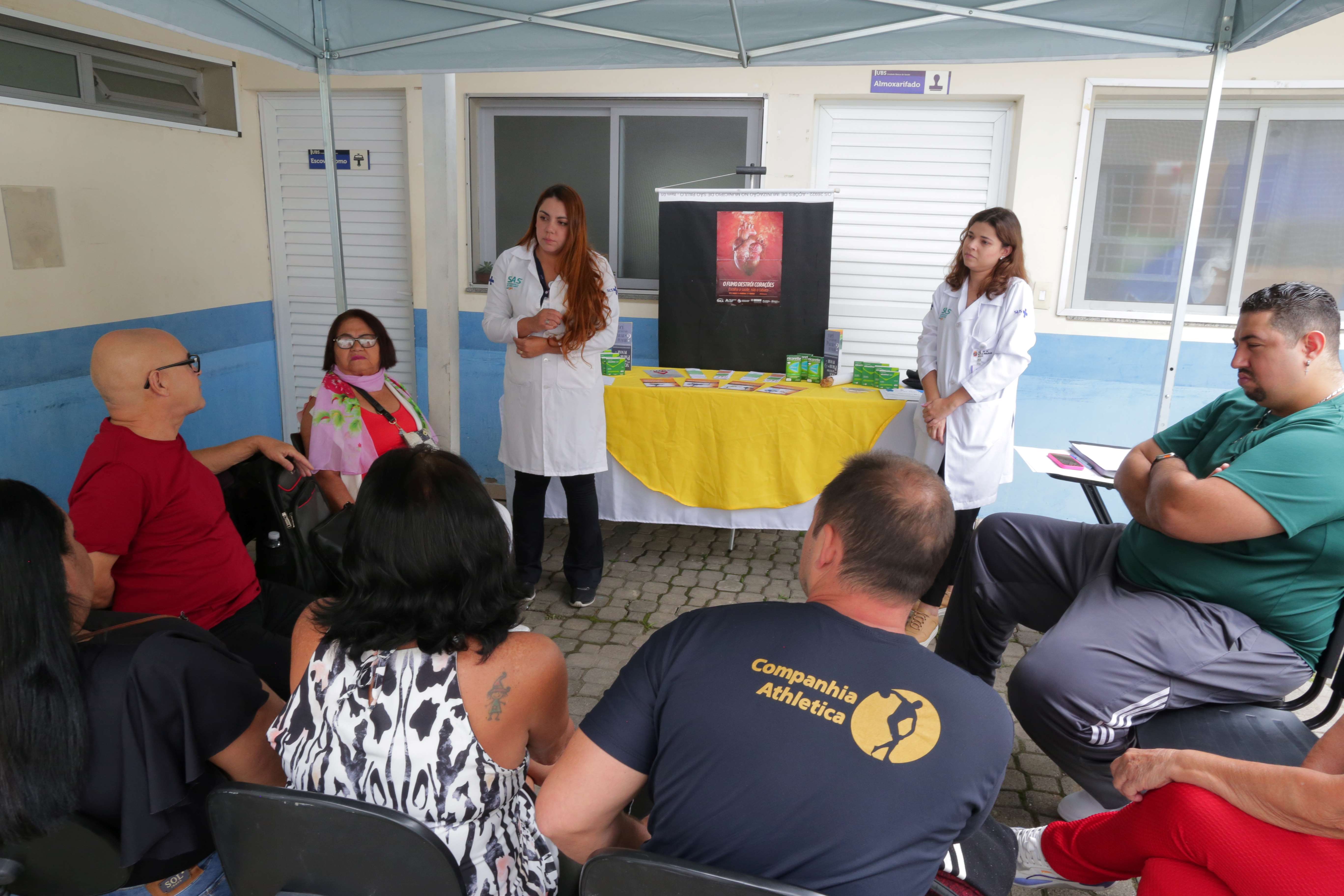 Profissionais da Secretaria Municipal da Saúde (SMS) realizam atividade educativa em grupo sobre os riscos do tabagismo e os benefícios da cessação do hábito de fumar. A ação acontece em uma unidade de saúde, reunindo usuários e equipe multiprofissional em uma roda de conversa para orientação, acolhimento e compartilhamento de informações sobre prevenção e tratamento da dependência da nicotina.