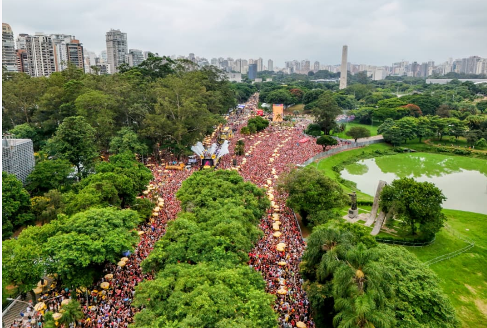 A imagem mostra uma multidão gigantesca ocupando a área em frente ao Monumento às Bandeiras, no Parque do Ibirapuera, durante o pré-Carnaval de São Paulo,