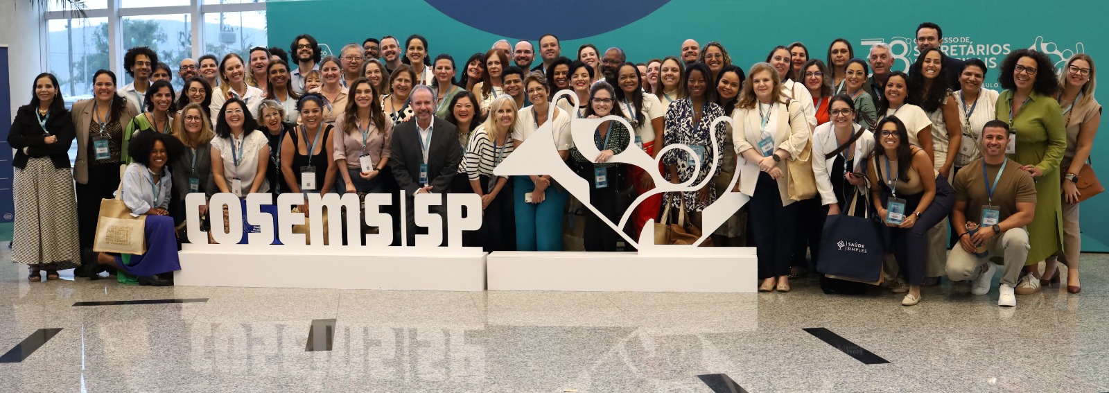 Profissionais da Secretaria Municipal da Saúde de São Paulo participam do 38º Congresso do Conselho de Secretários Municipais de Saúde, reunidos em estande institucional. Na imagem, representantes da SMS-SP interagem com participantes, apresentam materiais informativos e compartilham experiências sobre a organização da rede municipal de saúde, com destaque para a Atenção Básica e estratégias de cuidado no território.