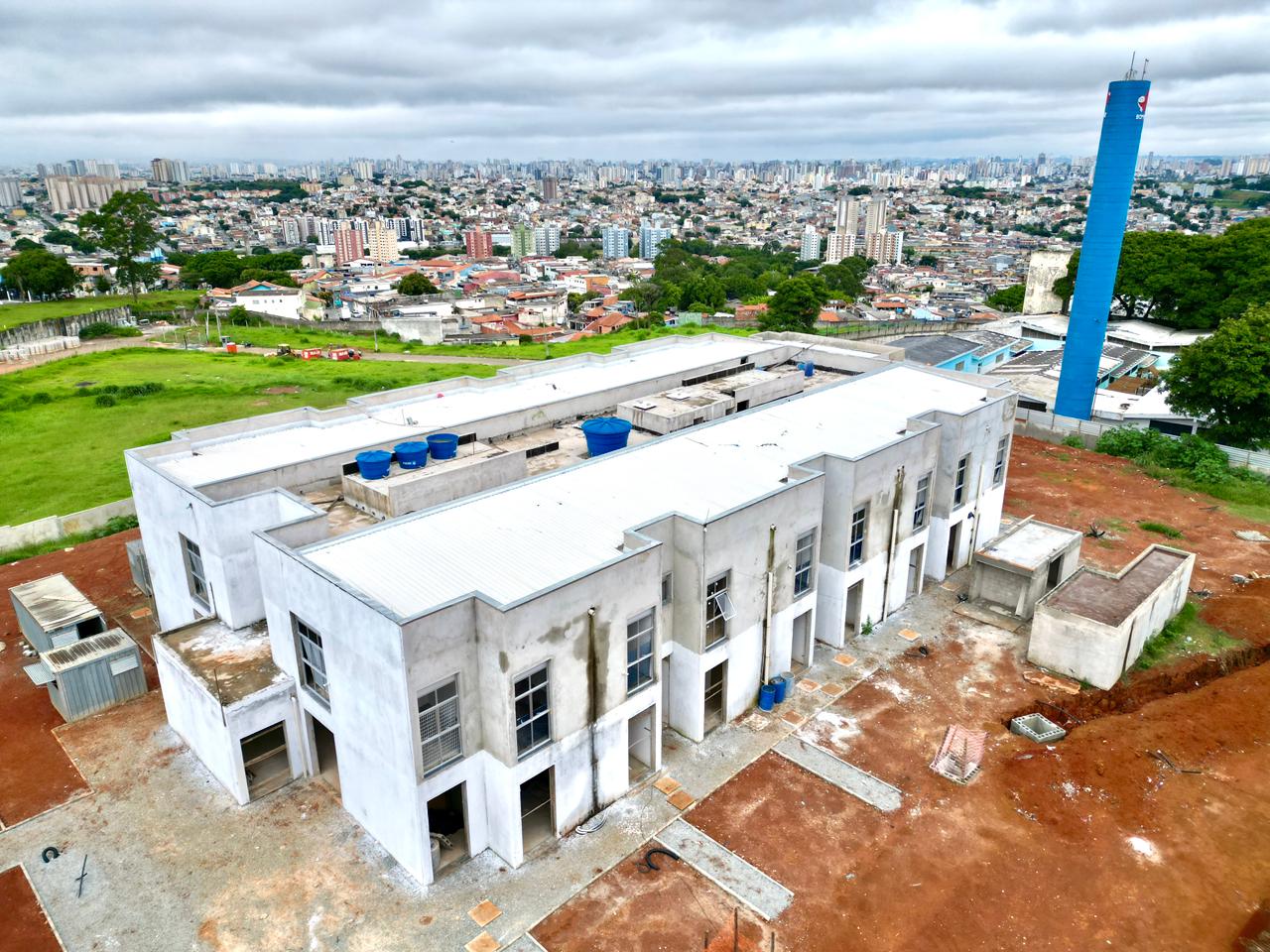 A foto aérea tirada por drone mostra as obras do prédio da UPA Sapopemba. O edifício em construção ocupa um grande espaço e terá janelas amplas.