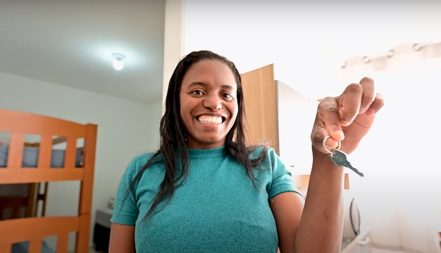 Mulher recebe a chave de sua casa