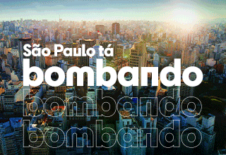 Imagem animada mostrando uma vista aérea da cidade de São Paulo, com vários prédios iluminados pelo sol. Em destaque, aparece o texto em letras grandes e brancas: São Paulo tá bombando, acompanhado de uma bandeira da cidade