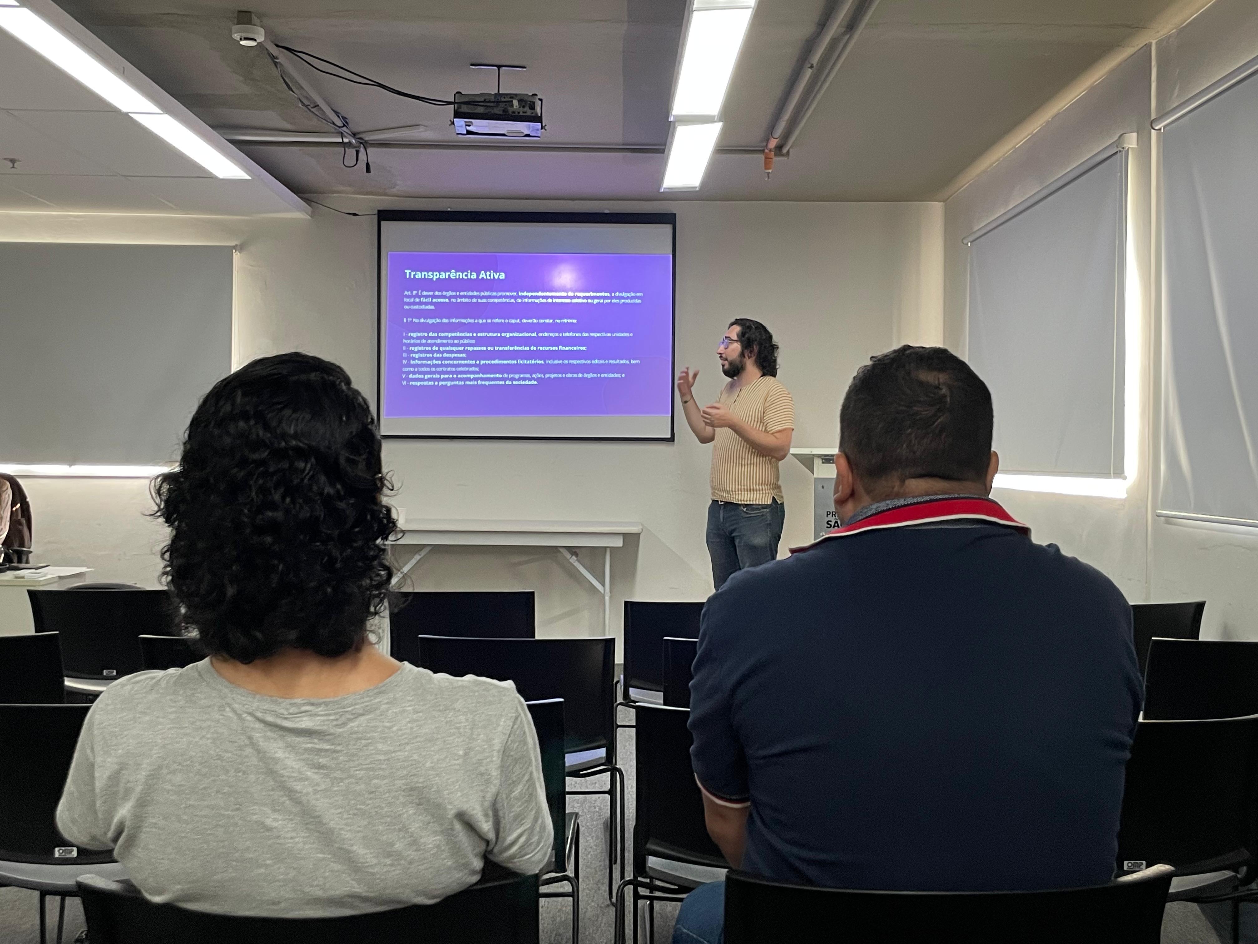 Homem realizando palestra em auditório.