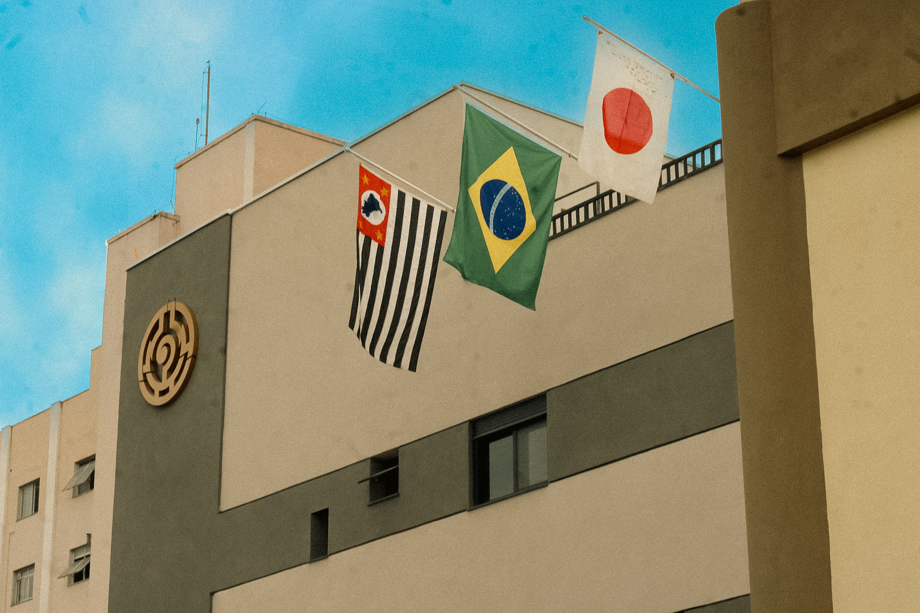 Nova faixada do prédio e as bandeiras do estado de São Paulo, Brasil e Japão