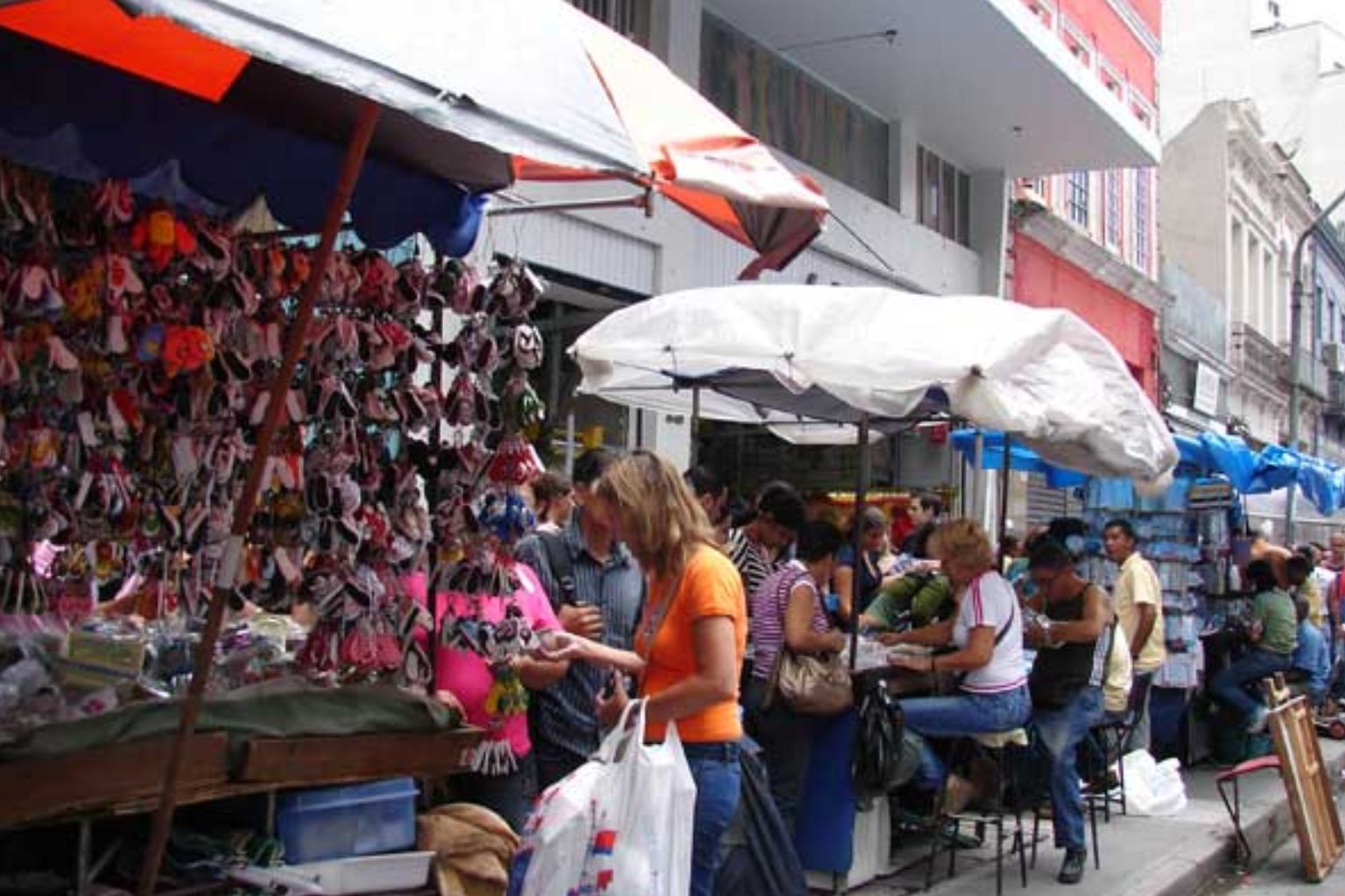 Imagem de vendedores ambulantes estabelecendo seu comércio nas calçadas.