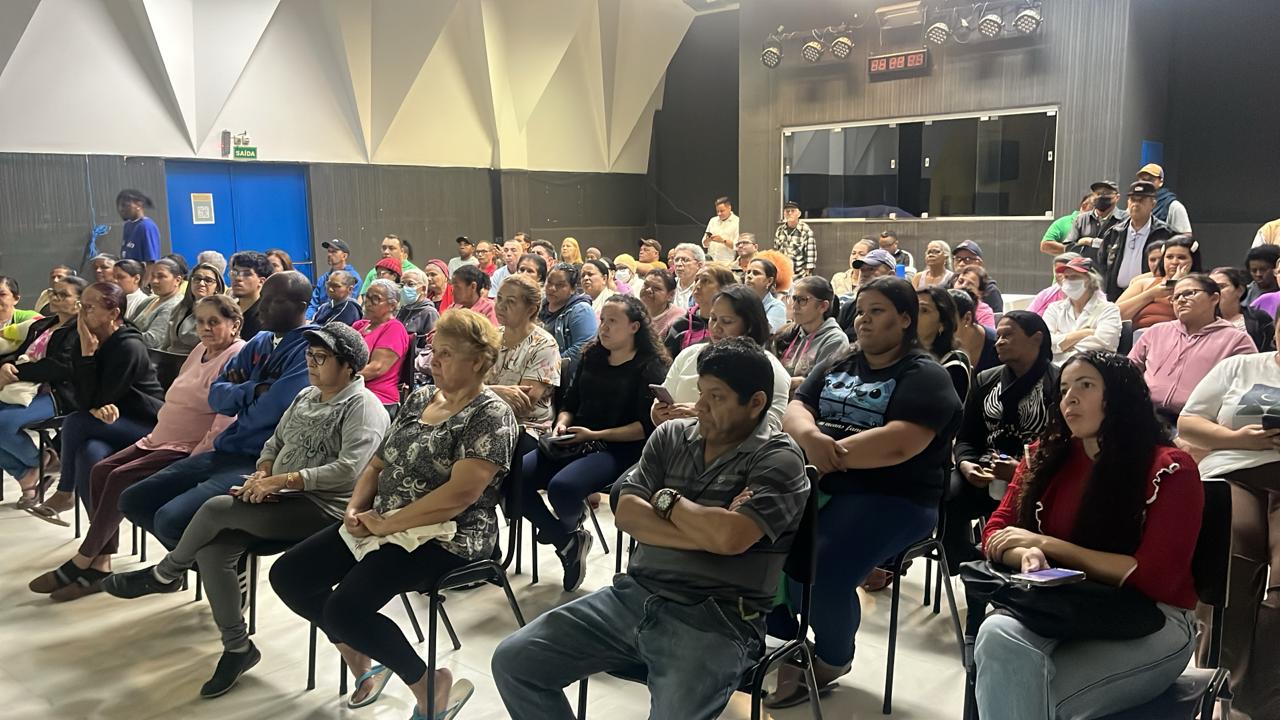 Lideranças do Conjunto Real Parque sentadas em auditório para reunião com a equipe de Regularização Fundiária.