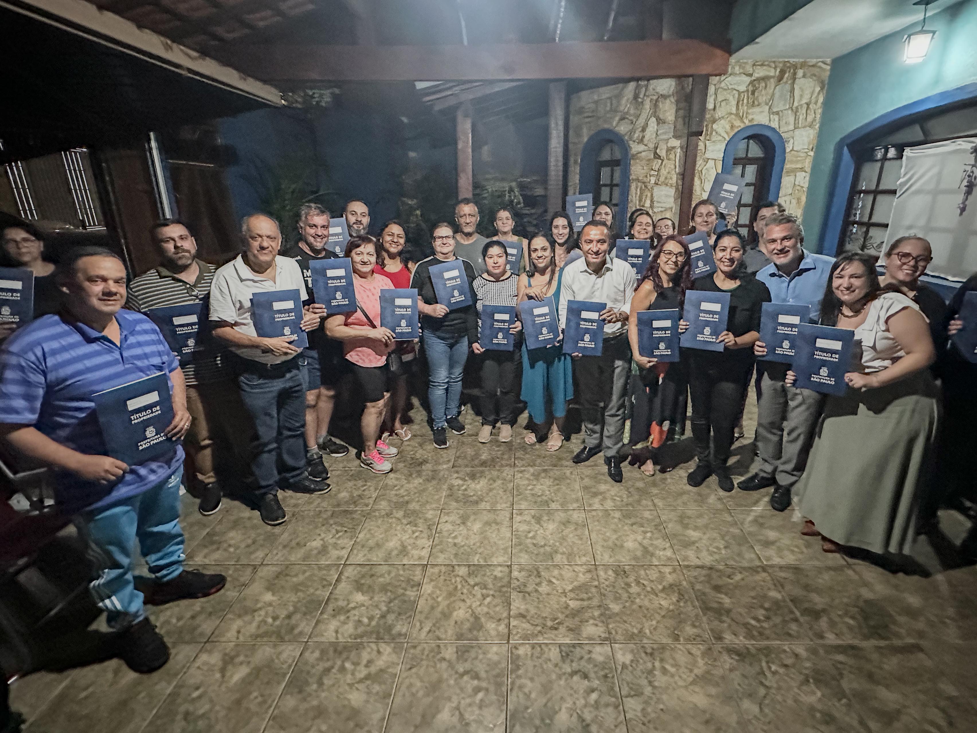 Secretário Sidney Cruz junto com moradores da Vila Formosa que receberam seus títulos de propriedade.