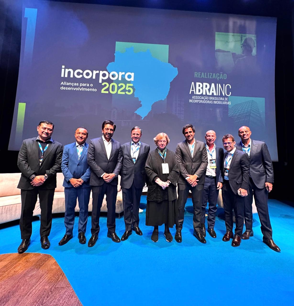 Prefeito Ricardo Nunes, Sidney Cruz, Elisabete França, Diogo soares e outros participantes posando para foto com o painel atrás escrito 