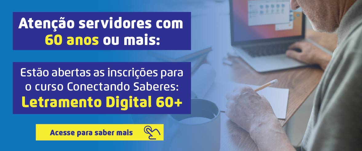 Atenção servidores com  60 anos ou mais: Estão abertas as inscrições para o curso Conectando Saberes:  Letramento Digital 60+ Acesse para saber mais Ao lado direito, temos a fotografia de perfil de um homem que aparenta ter mais de 60 anos, sentado à mesa, escrevendo em uma folha de papel com a mão esquerda enquanto clica nas teclas de um notebook que está ao seu lado direito.
