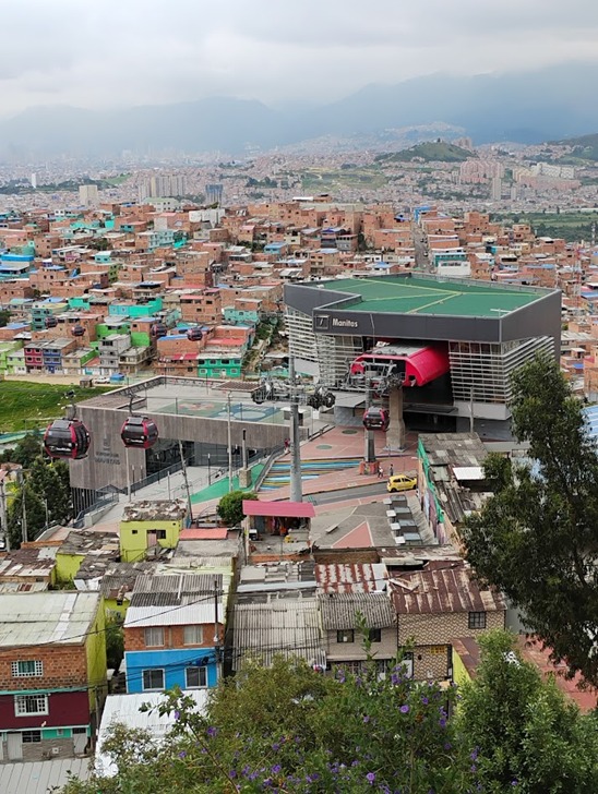 A primeira mostra uma estação de teleférico urbano em uma área de morro, identificada como Estación Manitas, em Medellín (Colômbia). É parte do Metrocable, sistema de transporte público integrado ao metrô da cidade.