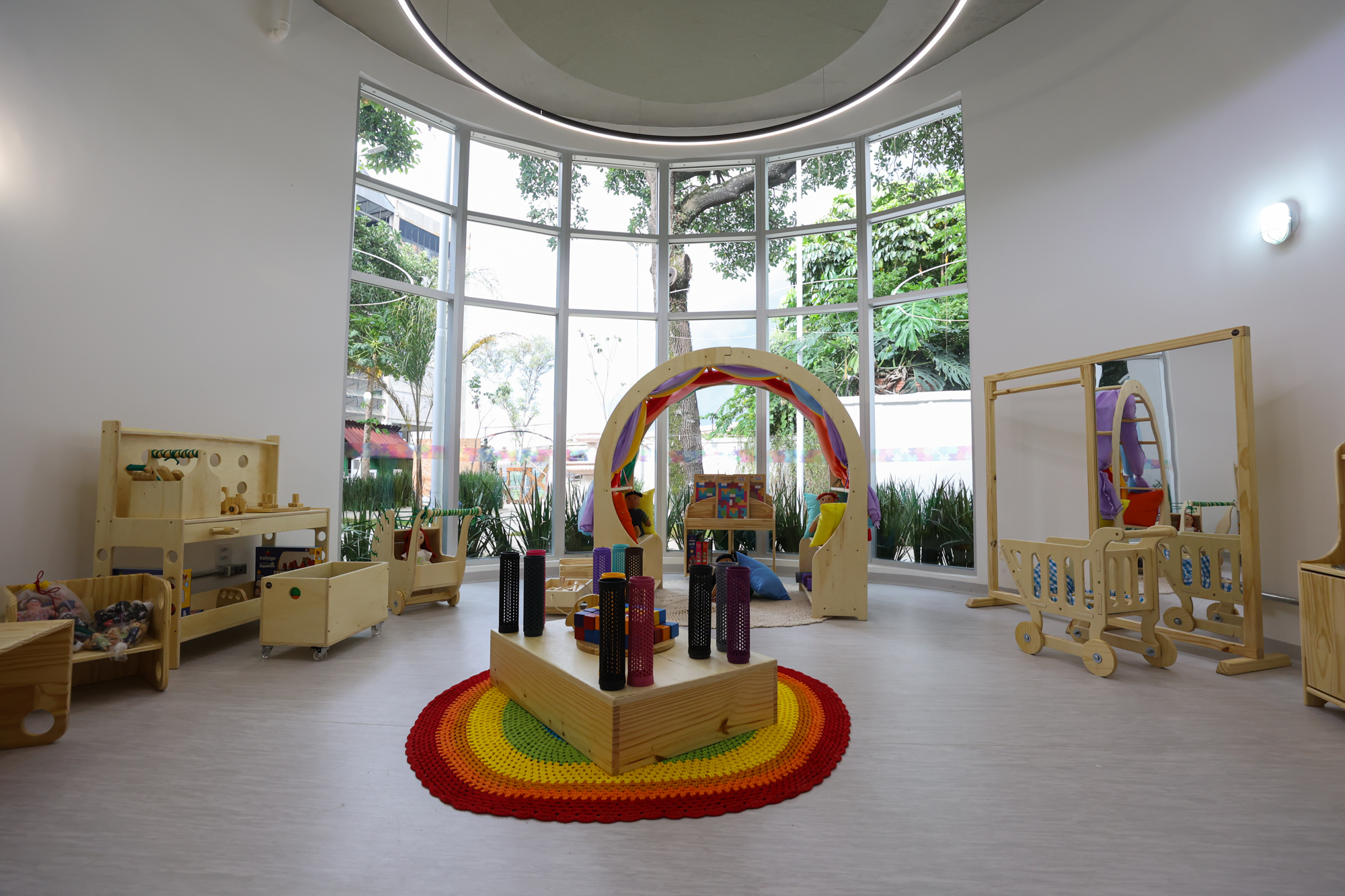 Imagem da brinquedoteca do Centro TEA. Uma sala arredondada com objetivos educativos de madeira.